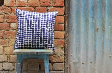 white, black, and purple throw pillow on square stool
